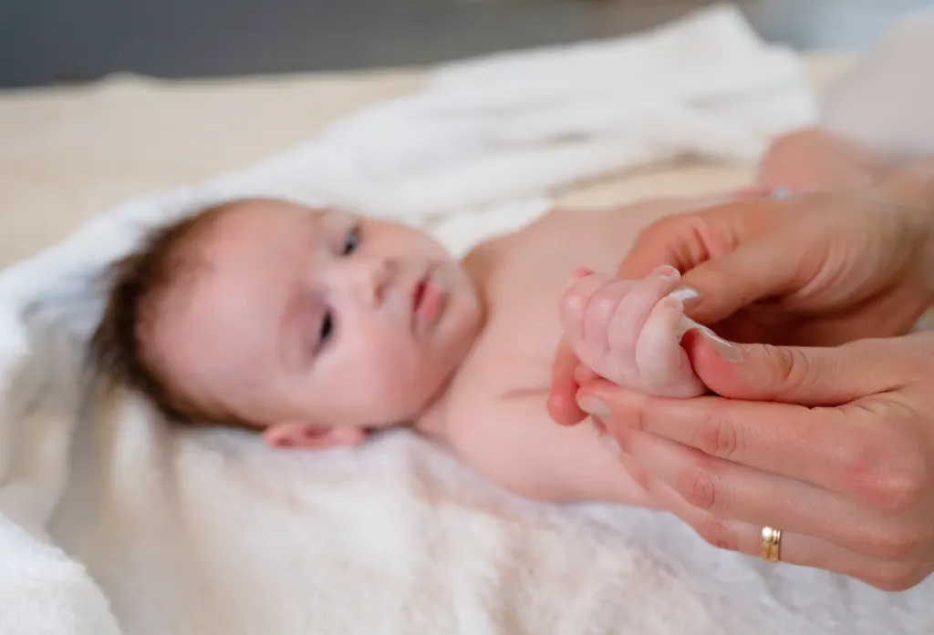 Zwei Mütter massieren ihre Babys nebeneinander im Kurs